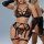 Woman modeling black lace lingerie set with sheer bra, garter belt, and gloves.