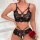 Woman modeling black lace lingerie set with sheer panels, cut-out details, and matching sleepwear, holding a red rose.
