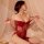 Woman wearing red lace lingerie sleepwear set with sheer mesh cami and tie straps, posing seductively on bed.