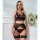 Woman modeling black lace lingerie set with sheer bra, panty, and garter straps in elegant room.