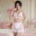Woman modeling pink and white sexy lace maid costume set with sheer mesh, lace trim, bow accents in romantic bedroom setting.