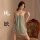 Woman wearing a sexy lace mesh backless nightgown, sitting on an ornate chair with floral upholstery.