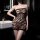 Woman wearing a black lace mesh halter dress with open-crotch design, showcasing premium bodycon erotic lingerie in a modern ...