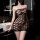 Woman wearing black mesh halter dress with open-crotch design in modern bathroom.