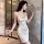 Elegant champagne glass beside a woman wearing a silky beige dress with a high slit and delicate chain detail, perfect for ev...