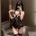 Woman modeling black sheer lace lingerie set with open-crotch bustier dress and thigh-high stockings in mirror selfie.