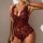 Woman wearing red and black lace sheer bodysuit with floral embroidery, deep v-neck, and garter belt details.