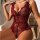 Woman wearing red and black lace sheer bodysuit with floral embroidery, deep v-neck, bow straps, and elegant european-style m...