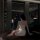 A woman sits on a couch wearing a sheer lace sleep dress set, featuring cut-out details and delicate straps, perfect for a ni...