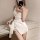 Woman wearing white lace sleep dress with silk wrap, posing in mirror for date night romance look.
