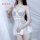 Woman wearing white lace sleep set with sheer mesh backless nightgown, underwire bra, and matching briefs.