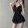 Woman wearing black lace sleepwear set with sheer skirt and bow detail, posing seductively in flirty lingerie dress.