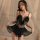 Woman modeling black lace sleepwear set with deep v-neck, adjustable straps, and sheer cut-out details.