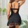 Woman wearing black lace slip dress with sheer back and floral hem, part of a seductive lingerie set.