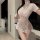 Woman wearing sheer lace cheongsam lingerie with split sides and butt-revealing design in modern kitchen setting.