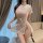 Woman wearing a sexy sheer lace cheongsam lingerie set with a high split and seductive design.