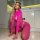 Woman kneeling in a vibrant pink sexy leopard lace bodysuit, featuring sheer mesh and elegant cutouts.