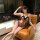 Woman lounging in a sexy leopard print lingerie set, featuring a seductive bodysuit with black trim, perfect for boudoir or s...