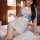 Woman in blue and white secretary-style lingerie set with lace details, posing on bed for date night look.