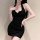Woman wearing black ribbed halter dress with ruched waist, paired with sheer stockings and delicate jewelry.