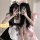 Two individuals wearing matching black and white maid costumes with bows, posing for a mirror selfie. the outfits feature ruf...