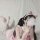 A woman in a pink maid costume with cat ears blows cotton candy, creating a playful and whimsical scene. the outfit features ...