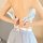 Woman adjusting the back of a blue and white gingham maid costume with lace trim, featuring a bow at the waist.