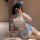 Woman in blue and white sexy maid costume with bow headband, posing playfully on floor — seductive lingerie set for couples.