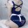 Woman wearing a sexy maid costume with a navy blue bodysuit, white apron, and ruffled sleeves.