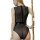 Woman wearing a sheer mesh bodysuit with back zipper and patent leather waistband, posing by a pole.