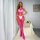 Woman wearing a pink mesh lingerie set with sheer lace bodysuit and fishnet stockings, posing elegantly in a bright room.
