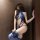 Woman wearing a blue lace halter bodysuit with sheer panels and garter straps, posing against a wooden wall.