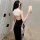 Woman wearing a black and white sexy nun costume lingerie set with lace trim, taking a mirror selfie.