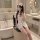 Woman in white sexy nurse costume set with lace-up lingerie, posing in bathroom for couples bedroom play attire.