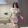 Woman wearing sexy nurse costume with lace cut-outs, pink uniform set, and red stethoscope for adult role play.