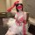Woman in red and white lacy nurse costume with tulle skirt, posing for role play or cosplay.