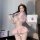 Woman in pink sexy nurse costume with heart cutouts, holding medical box; plus size role play lingerie set.