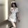 Woman wearing white sexy nurse costume with red cross hat, deep v-neck dress, and lace thigh-high stockings for role play.