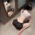 Woman in sexy ol secretary costume lingerie set - provocative bodycon sleepwear for women, posing on floor with mirror reflec...