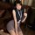 Woman wearing a sexy ol secretary outfit with a high-waisted bodycon skirt and slim-fit top, accessorized with a lanyard.