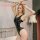 Woman modeling black patent leather bodysuit with side cutouts, backless design for nightclub, parties, cosplay.