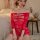Woman wearing a bold red striped sheer mesh bodysuit with lace details, styled as seductive plus-size lingerie in a cozy bedr...