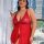 Woman in red lace halter sleep dress, sheer elegant nightgown for plus size, holding wine glass by window.