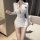 Woman wearing white sexy police cosplay costume with gold buttons, featuring a deep v-neck and short skirt, styled as a naugh...
