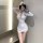 Woman wearing white flight attendant cosplay costume with gold buttons and hat, posing in sexy ol secretary lingerie outfit.