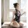 A woman wearing a black floral printed cheongsam lingerie sits gracefully by a window, holding a feather fan. the design feat...