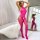 Woman posing in a vibrant pink, sheer floral lace bodystocking with side cutouts and bow details, displayed in a bright bedro...