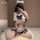 A person wearing a cute schoolgirl outfit, featuring a sailor-style top with ruffles and a large bow, paired with matching sh...