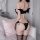 Woman wearing black pvc devil wings lingerie set with matching thong and stockings, anime-style cosplay outfit for women.