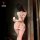 Woman wearing sexy ripped sheer mesh bodysuit with provocative cut-outs, back view showing lace thong top design.